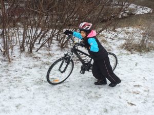 Child Pushing a Mountain Bike in the Snow