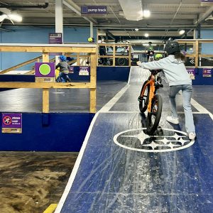 Young rider pushing her bike up the ramp at Joyride 150.