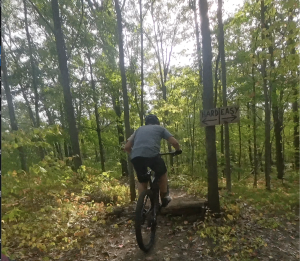 Cory Purchase riding over a log feature on the CP Rail trail in Woodnewton.